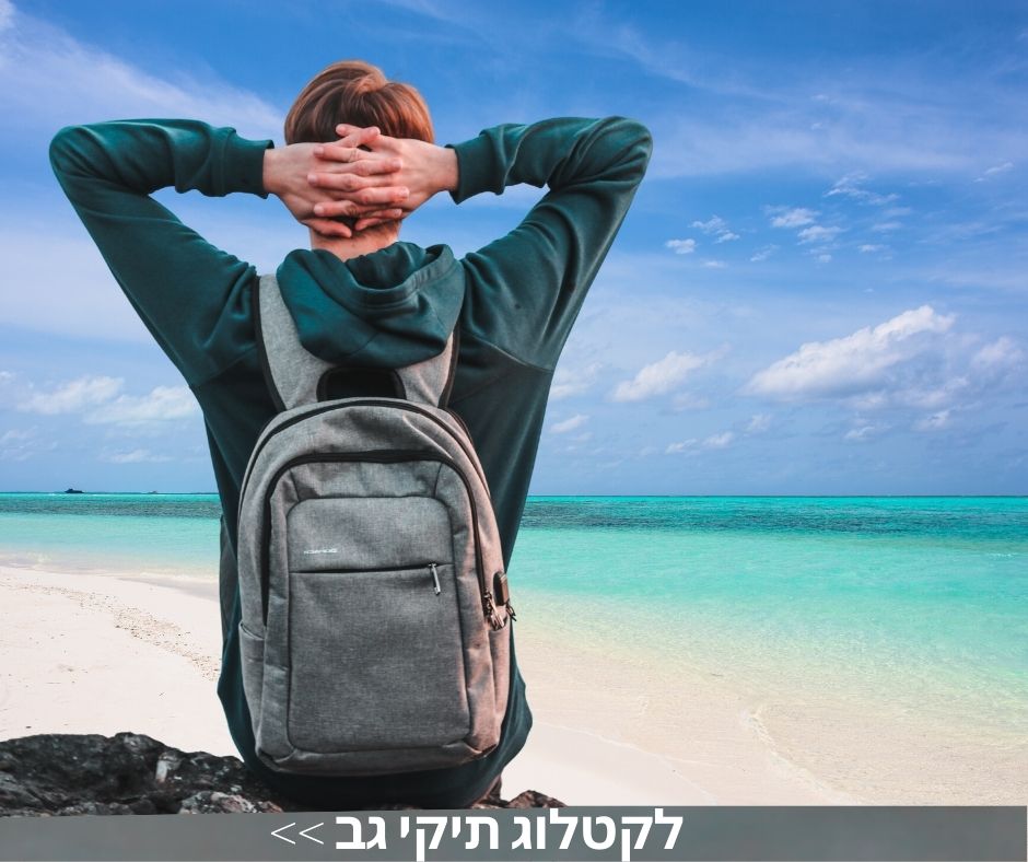בחור יושב בחוף הים עם תיק גב ממותג בצבע אפור